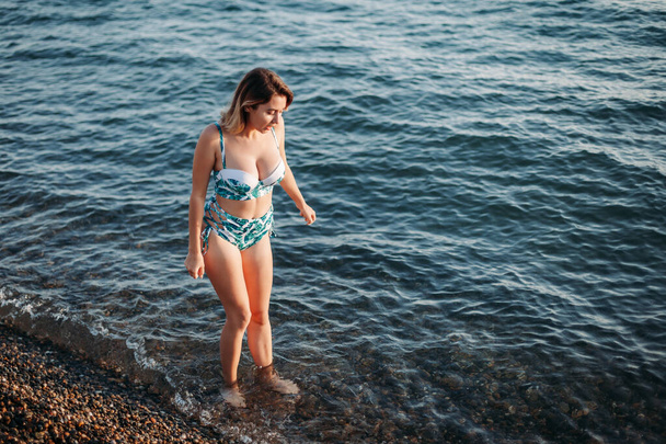 Happy woman in bikini swimwear walking on beach. Vacation, beaut - Zdjęcie, obraz