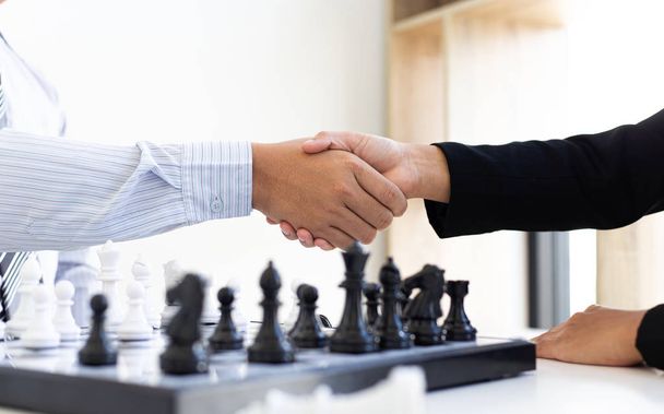 Both businessmen played chess to increase their business skills and held hands together for success, game concept. - Foto, imagen