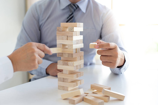Business people play wooden games together, divide the average investment value of a business and jointly manage risks, Alternative risk plan and strategy in business. - Фото, зображення