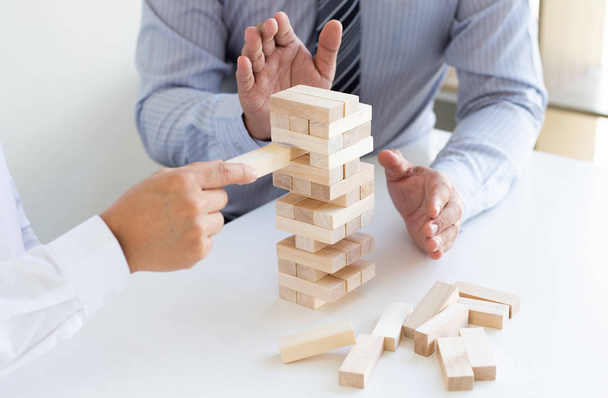 Business people play wooden games together, divide the average investment value of a business and jointly manage risks, Alternative risk plan and strategy in business. - Фото, изображение