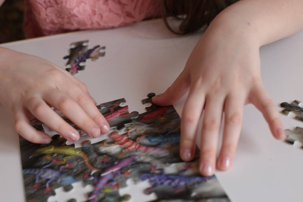 χέρια του παιδιού συλλέγουν παζλ παιχνίδια για το μυαλό και γρήγορη εξυπνάδα - Φωτογραφία, εικόνα