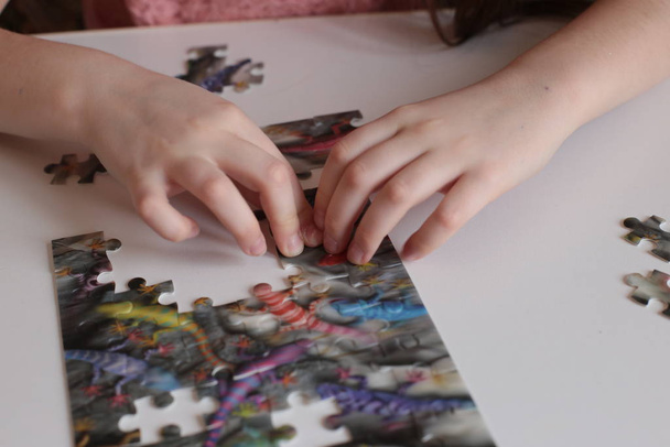 le mani del bambino raccolgono giochi di puzzle per la mente e ingegno rapido
 - Foto, immagini