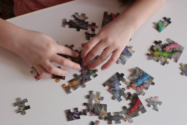 χέρια του παιδιού συλλέγουν παζλ παιχνίδια για το μυαλό και γρήγορη εξυπνάδα - Φωτογραφία, εικόνα
