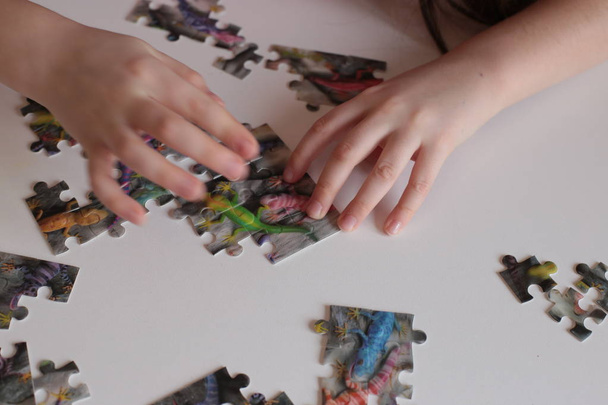 handen van het kind verzamel puzzels games voor de geest en snelle verstand - Foto, afbeelding