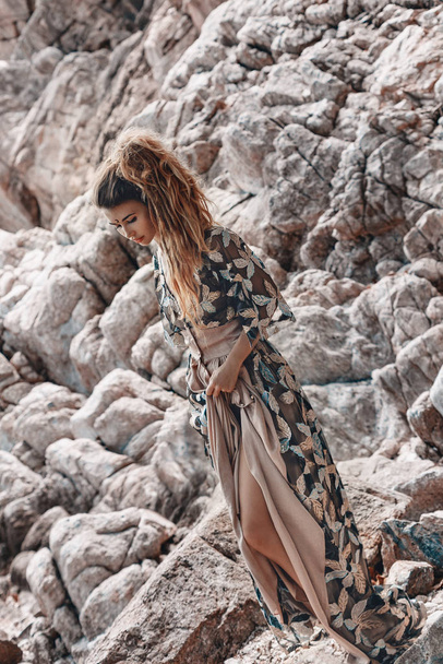 stylish young bohemian woman posing on stone beach background - Фото, зображення