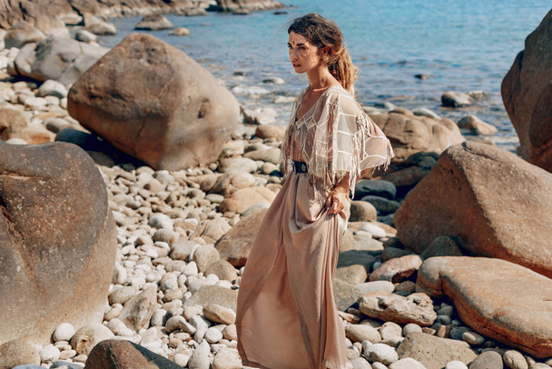 attractive boho girl posing on beautiful stone beach - Zdjęcie, obraz