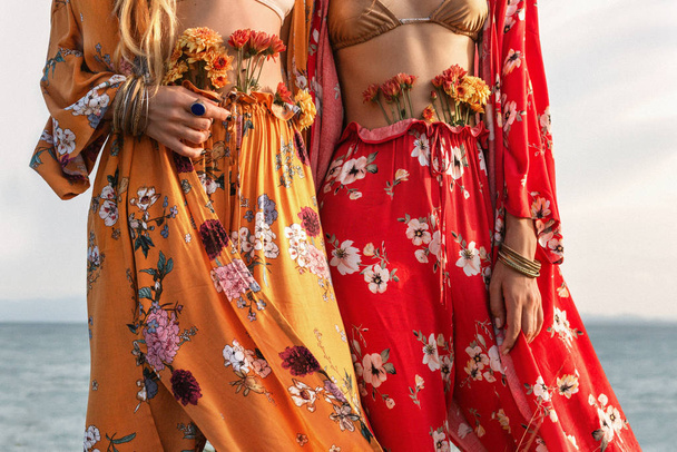 cropped image of bohemian style women with flowers and accessories - Zdjęcie, obraz