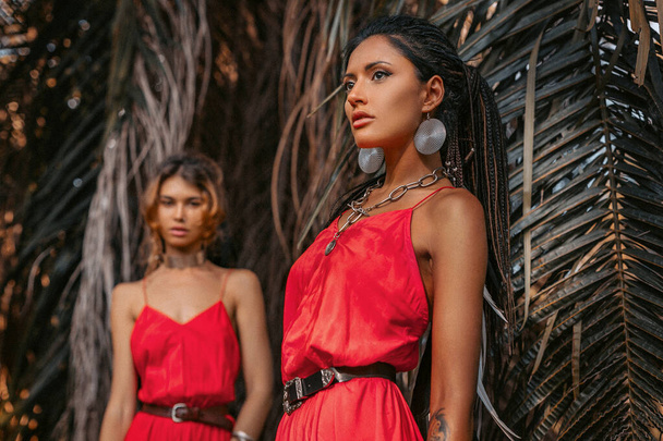 two beautiful young fashionable models in red dresses outdoors - Foto, Imagen