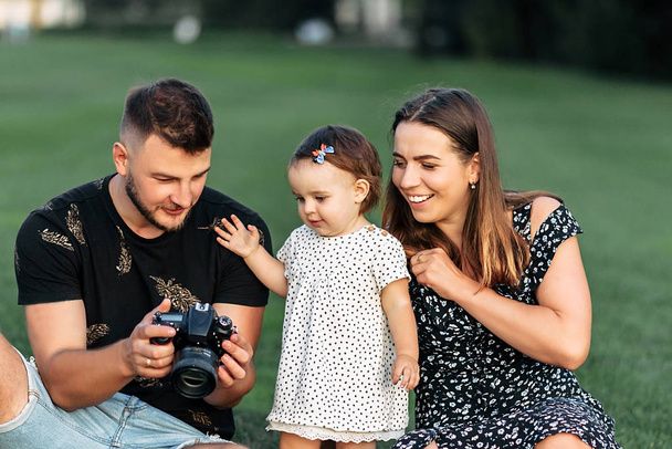 Portrait of a young family in the park - Фото, зображення