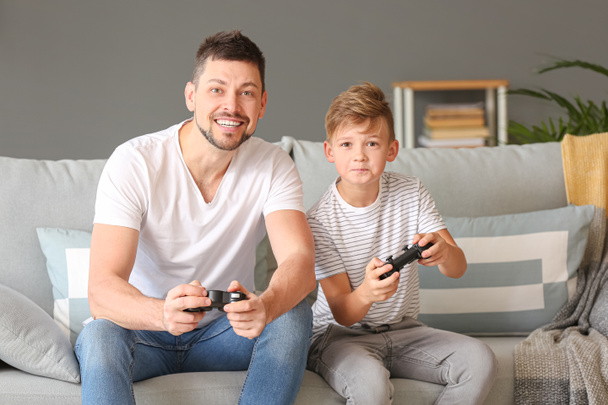 Father and his little son playing video games at home - Photo, Image