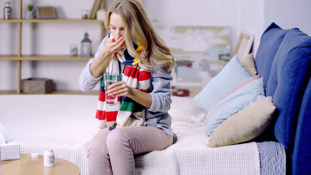 zieke vrouw met sjaal het nemen van pillen  - Video