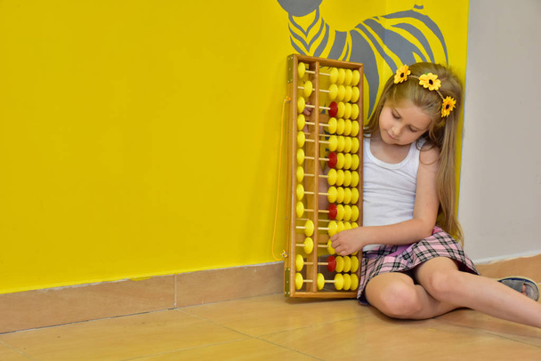 little girl with a wreath on her head and an abacus, - Fotoğraf, Görsel