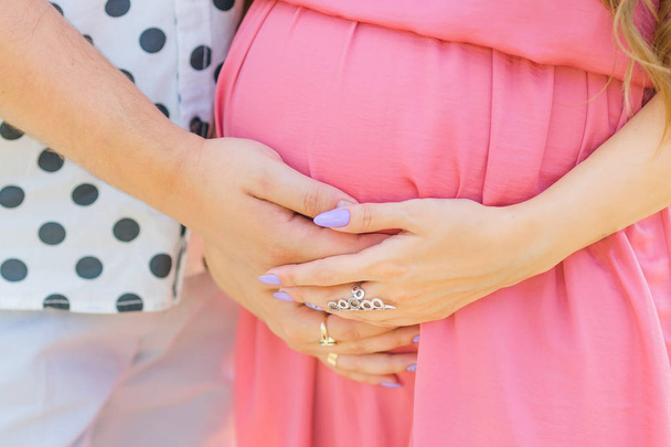 Закрыть человеческие руки, держащие беременный живот. беременная мать
 - Фото, изображение