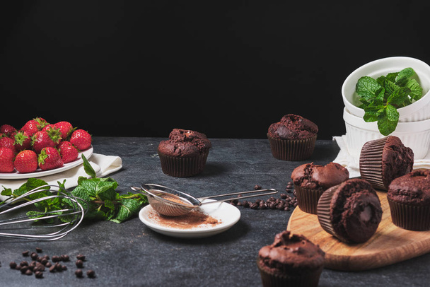 The process of making cupcakes. Dessert with cream, fresh berries, chocolate and mint. Chocolate ganache stuffed muffins. - 写真・画像