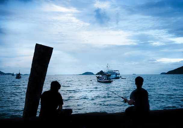 Silhouettes of the boys which are fishing - Photo, Image