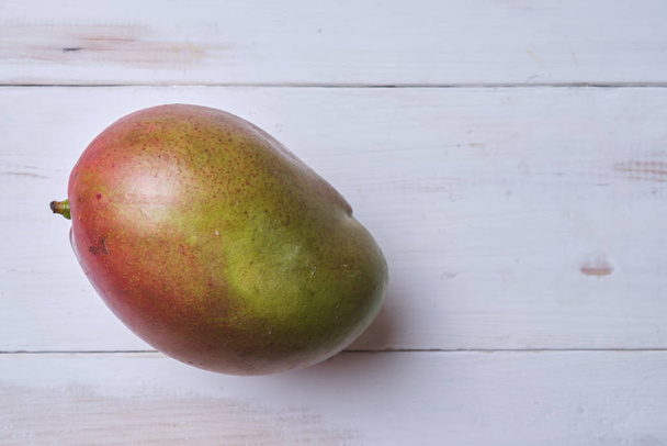 Mango on a white wooden table. Place for text. - Foto, Bild