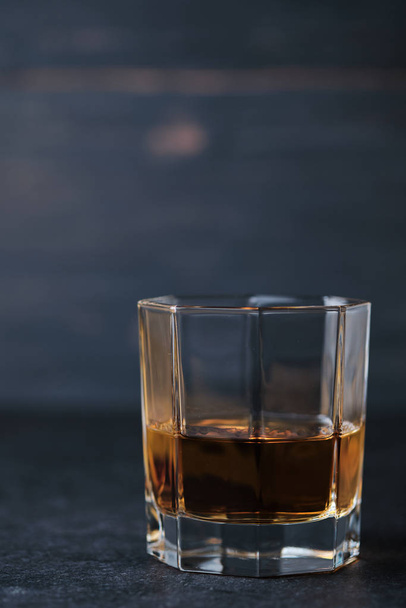 Стакан виски на деревянном столе в баре. Стойка бара с алкогольным напитком
. - Фото, изображение