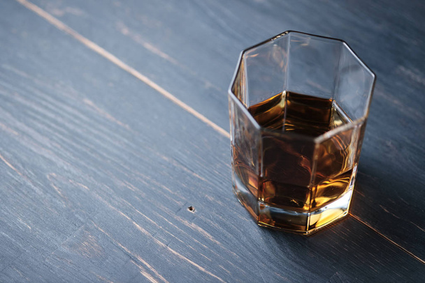 Ein Glas Whiskey auf einem Holztisch in einer Bar. Theke mit einem alkoholischen Getränk. - Foto, Bild