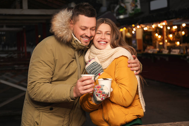 Happy couple with mulled wine at winter fair - Φωτογραφία, εικόνα