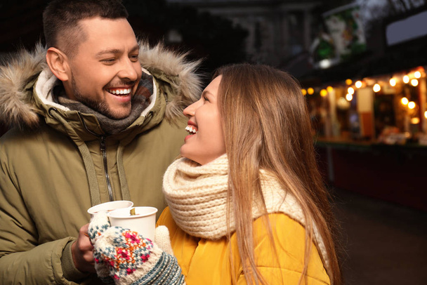 Happy couple with mulled wine at winter fair - Foto, Imagem