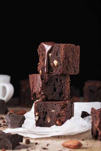 Schokoladenbrownie mit Nüssen und Minze. süßes und schmackhaftes Dessert mit Minze, Nahaufnahme auf einem Holztisch - Foto, Bild