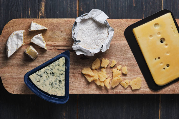 Dégustation de différents types de fromage. Plusieurs variétés de fromage sur une planche de bois. Vue du dessus
. - Photo, image