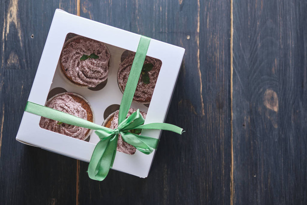 Loma cupcakes vaaleanpunainen kerma, koristeltu mintunlehtiä ja suklaalastuja. Jälkiruoka lahjana Ystävänpäivä
. - Valokuva, kuva