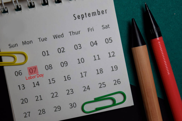 Vista superior Calendario mensual de septiembre y marcado séptimo día de trabajo aislado en el escritorio de la oficina
 - Foto, Imagen