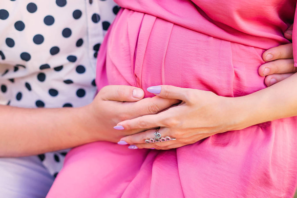 hombre y mujer tocan suavemente el vientre embarazada. De cerca. manos de ex
 - Foto, Imagen
