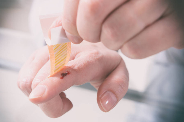 Aplicação de bandagem adesiva no dedo
 - Foto, Imagem