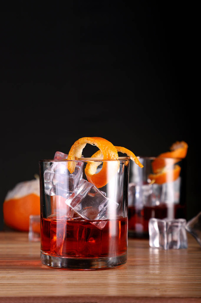 Whisky con alcohol refrigerado / bebida de ron con hielo y cáscara de naranja
 - Foto, Imagen