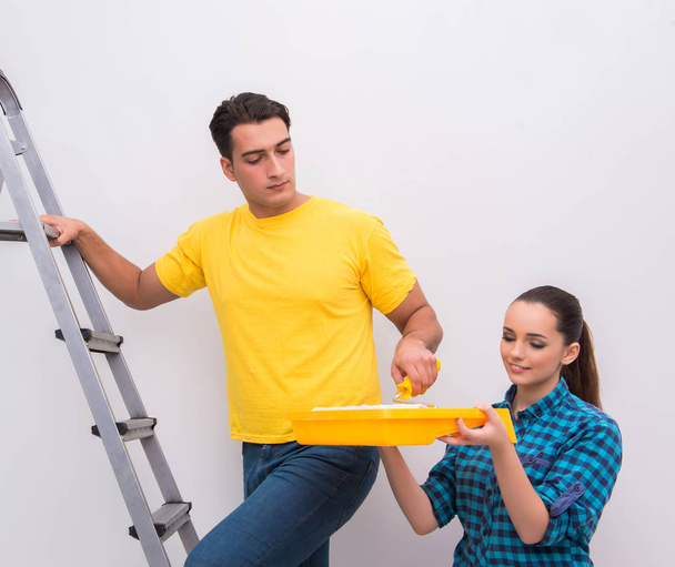 Jeune couple peinture mur à la maison
 - Photo, image
