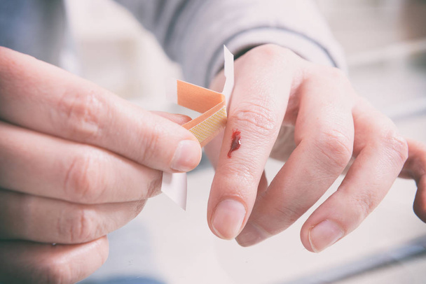 Applying adhesive bandage on finger - Foto, Imagem