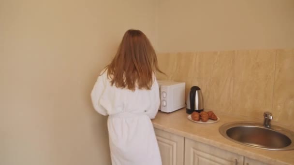 Woman in bathrobe hurrying at home. - Video