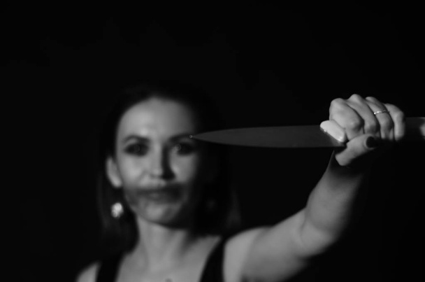 Wspaniała ruda kobieta z zakrwawionym nożem w ręku zbliżenie, koncepcja Halloween  - Zdjęcie, obraz