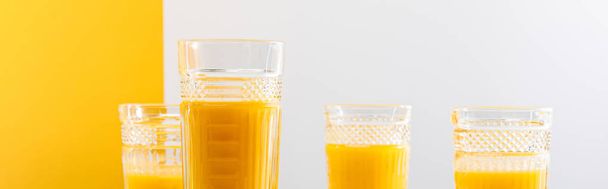 glasses of fresh delicious yellow smoothie on grey and yellow background, panoramic shot - Fotografie, Obrázek