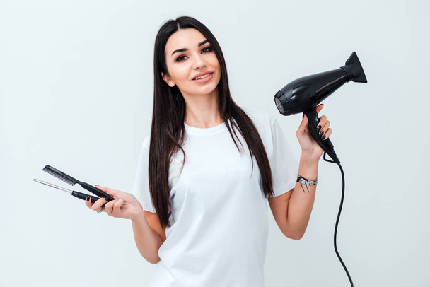 Professional hairdresser girl with comb hairdryer in hands on white background - Valokuva, kuva