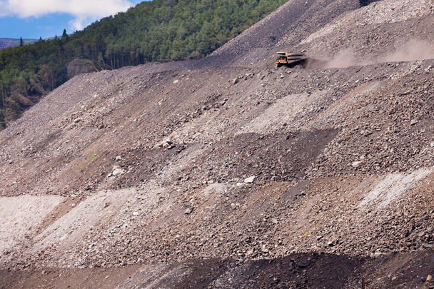 mijnbouw vrachtwagen op afstand weg bij afvalbassins heuvel kant - Foto, afbeelding