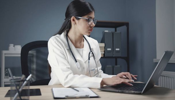 Doctor using laptop at work - Fotó, kép