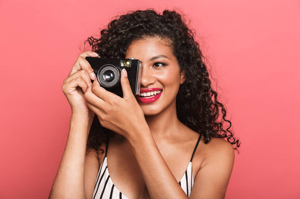 Image of pleased african american woman photographing on retro c - Zdjęcie, obraz