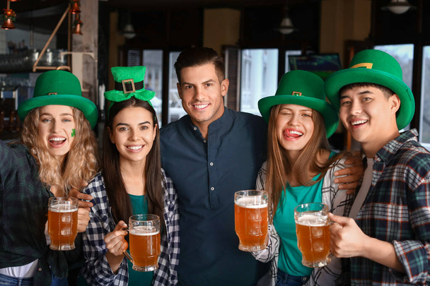 Young friends with beer celebrating St. Patrick's Day in pub - Zdjęcie, obraz