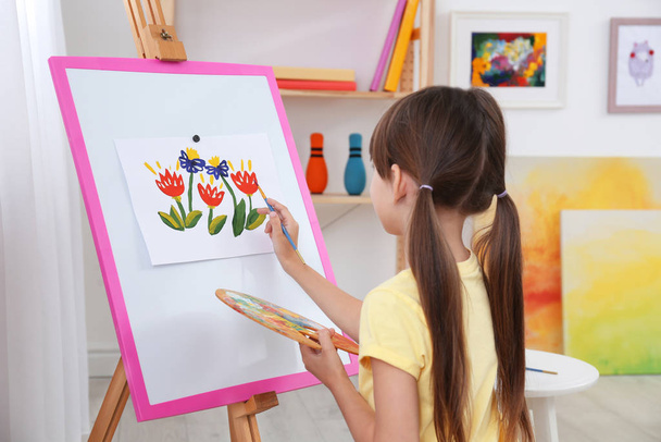 Cute little child painting during lesson in room - Фото, изображение