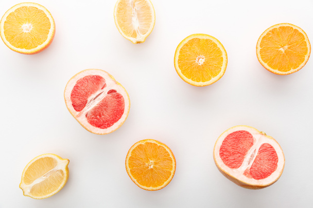 Top view of cut oranges, lemon, grapefruit halves on white background - Photo, Image