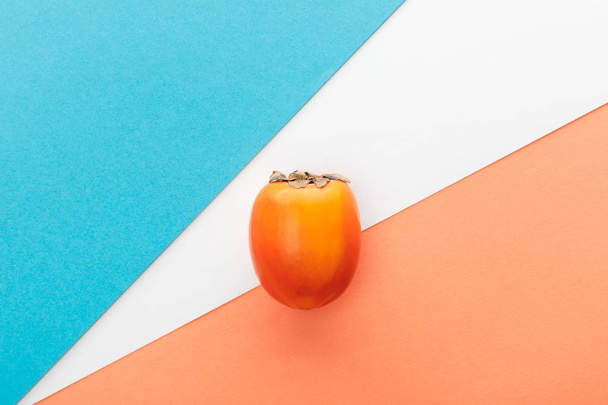 Top view of persimmon on white, orange and blue background - Foto, Bild