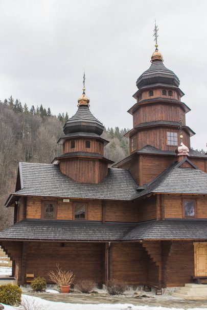 Antiguo edificio de madera del Monasterio del Santo Profeta Elías en el pueblo de los Cárpatos de Yaremche en invierno. Ucrania
 - Foto, Imagen