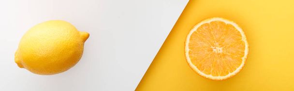 Widok z góry pomarańczowy pół i cytryna na żółto-białe tło, zdjęcie panoramiczne - Zdjęcie, obraz