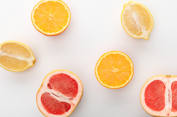 Top view of citrus halves on white background - Foto, Imagem