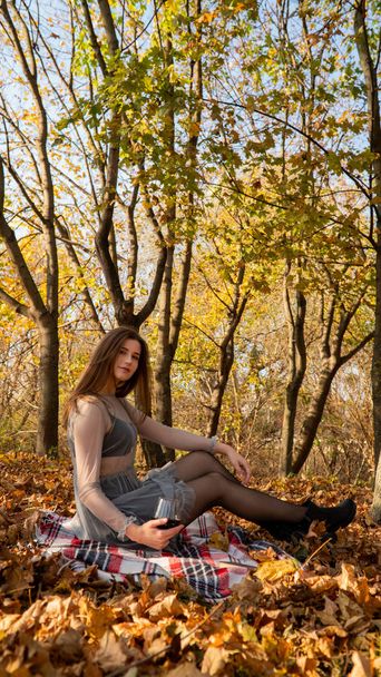 молода красива жінка з келихом вина в парку восени
 - Фото, зображення