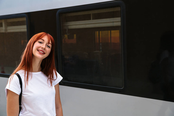 Κοντινό πλάνο πορτρέτο του κοριτσιού στο φόντο του τρένου - Φωτογραφία, εικόνα