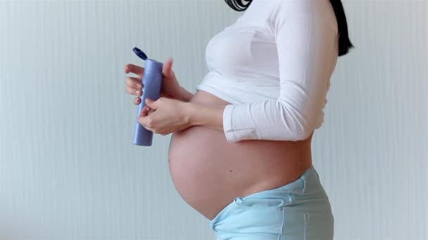 Closeup picture of pregnant woman. Unrecognizable expectant. Belly closeup. woman applying cream  - Felvétel, videó